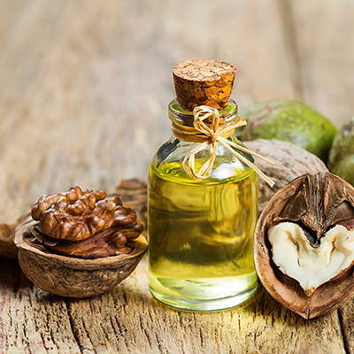 Walnussöl mit Walnüssen trapiert auf einem Holztablett